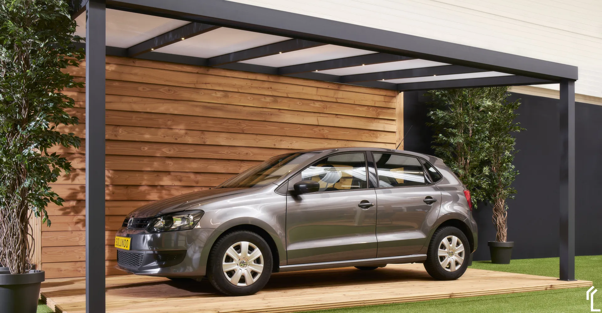 Antraciet overkapping als carport, met houten achterwand en een geparkeerde auto