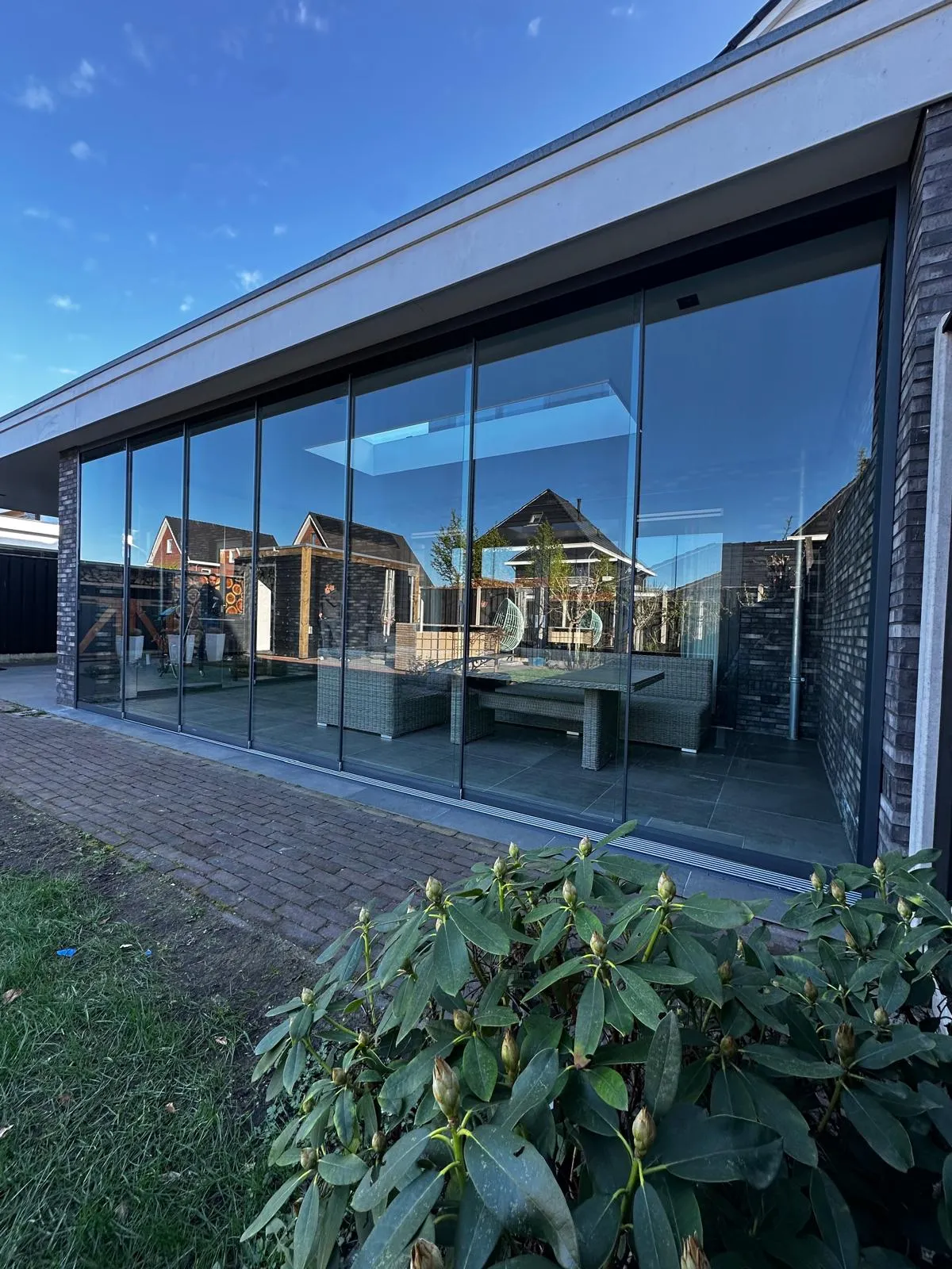 Tuinkamer met glazen schuifwanden aan de achterkant van een moderne woning